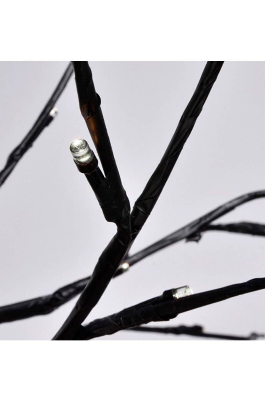 LED tree light close-up of black branch wiring with small bulb nodes at joints