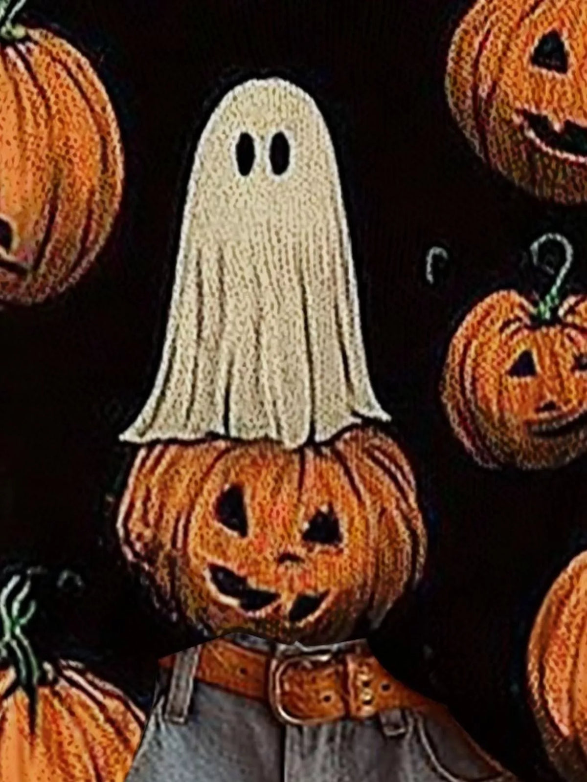 Black sweater detail close-up with ghost and jack-o'-lantern pumpkin graphics