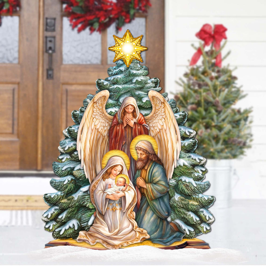 Outdoor nativity yard decoration with angel, Mary holding baby Jesus, and Joseph beside tree