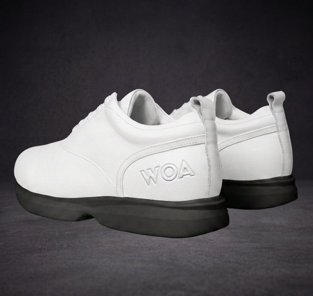 White WOA sneakers with lace-up design, side logo, and black soles