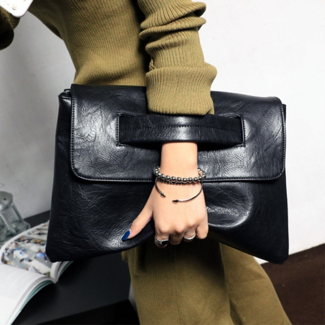 Black leather envelope clutch purse with front flap and structured top opening
