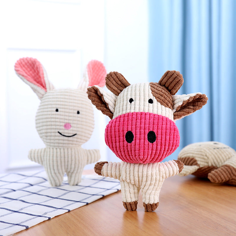 Pink-and-white cow-shaped plush dog toy with brown horns and hooves