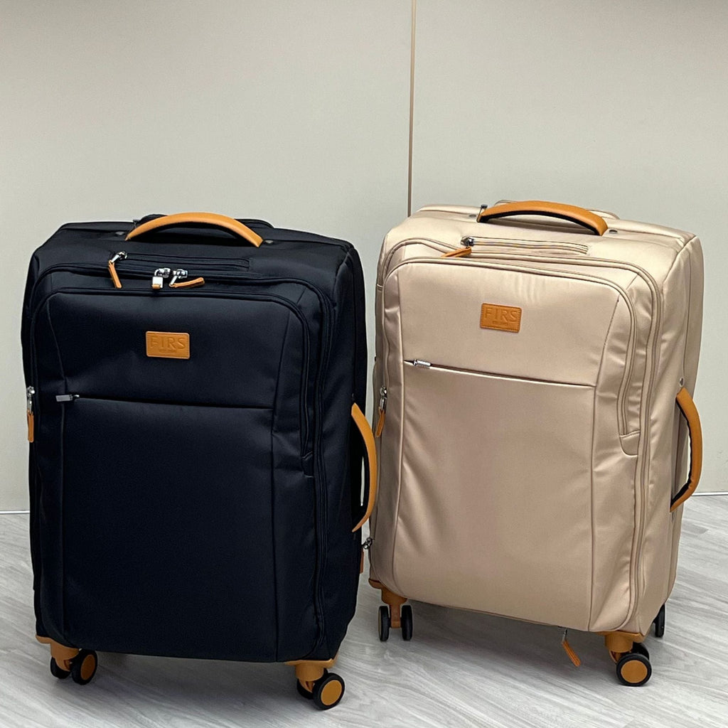 Pair of ultra-light wheeled trolley suitcases in black and cream with telescoping handles