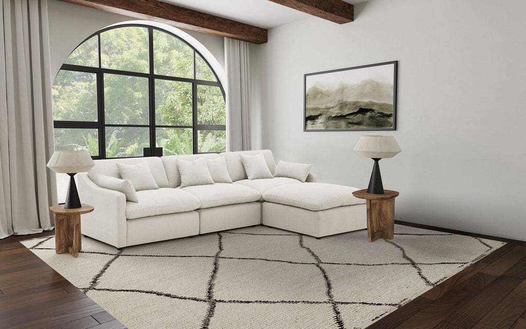 Ivory modular sectional sofa with chaise and tufted cushions, four-piece configuration