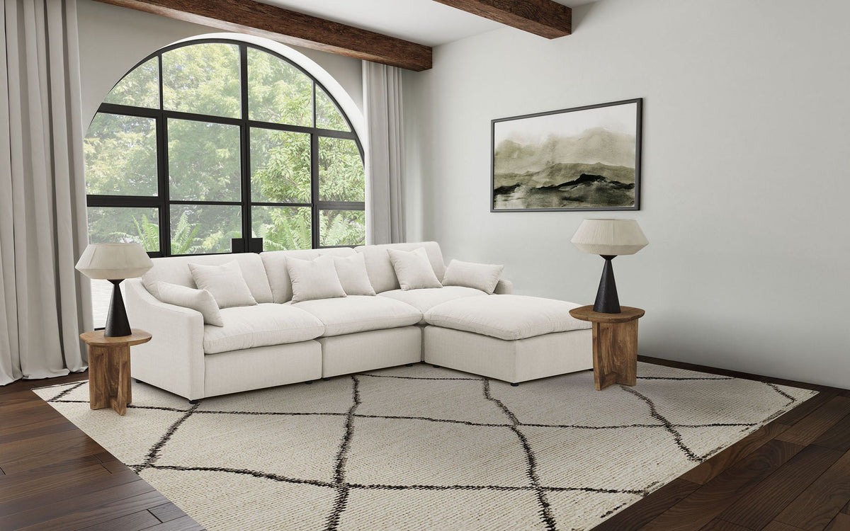 Ivory modular sectional sofa with chaise and tufted cushions, four-piece configuration