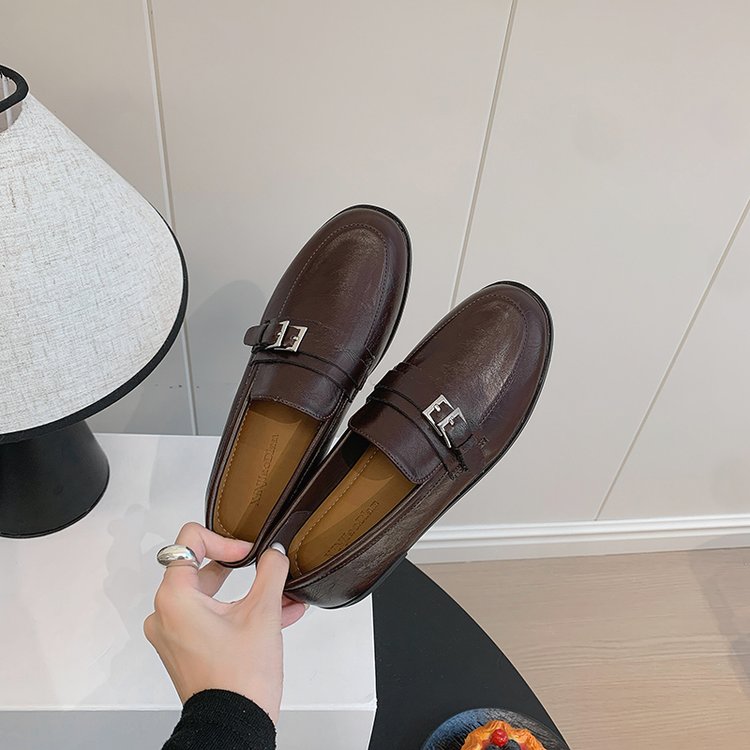 Brown women's loafers with metal buckle and decorative F plate, flat low heel.