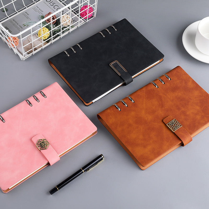 A5 loose-leaf notebooks with ring binders and buckle straps in black, brown, and pink