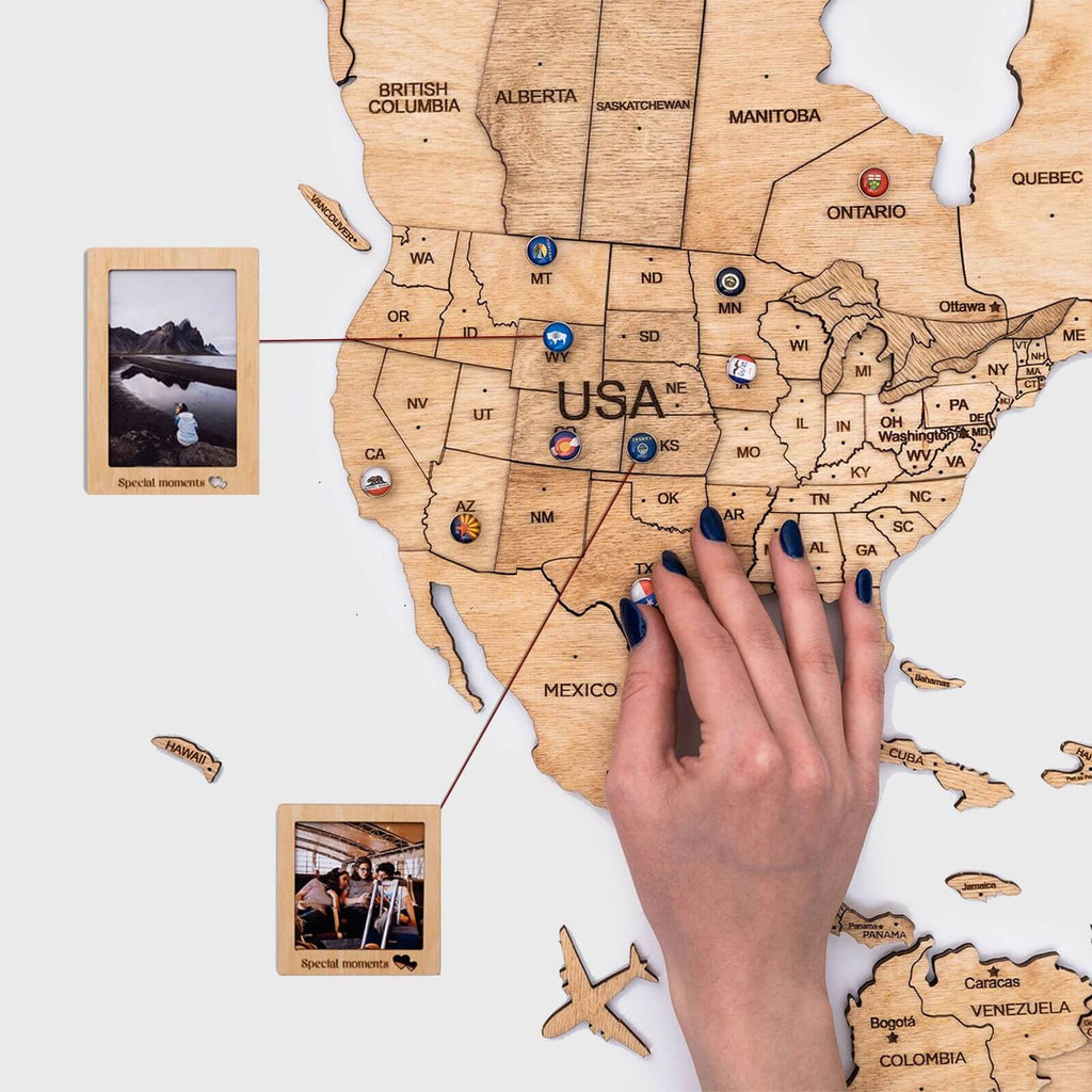 Wooden USA map with engraved state borders and labels, held by a hand
