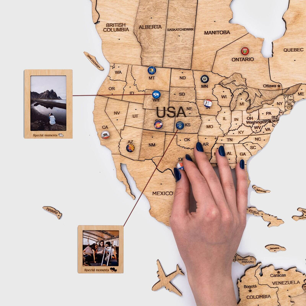 Wooden USA map with engraved state borders and labels, held by a hand