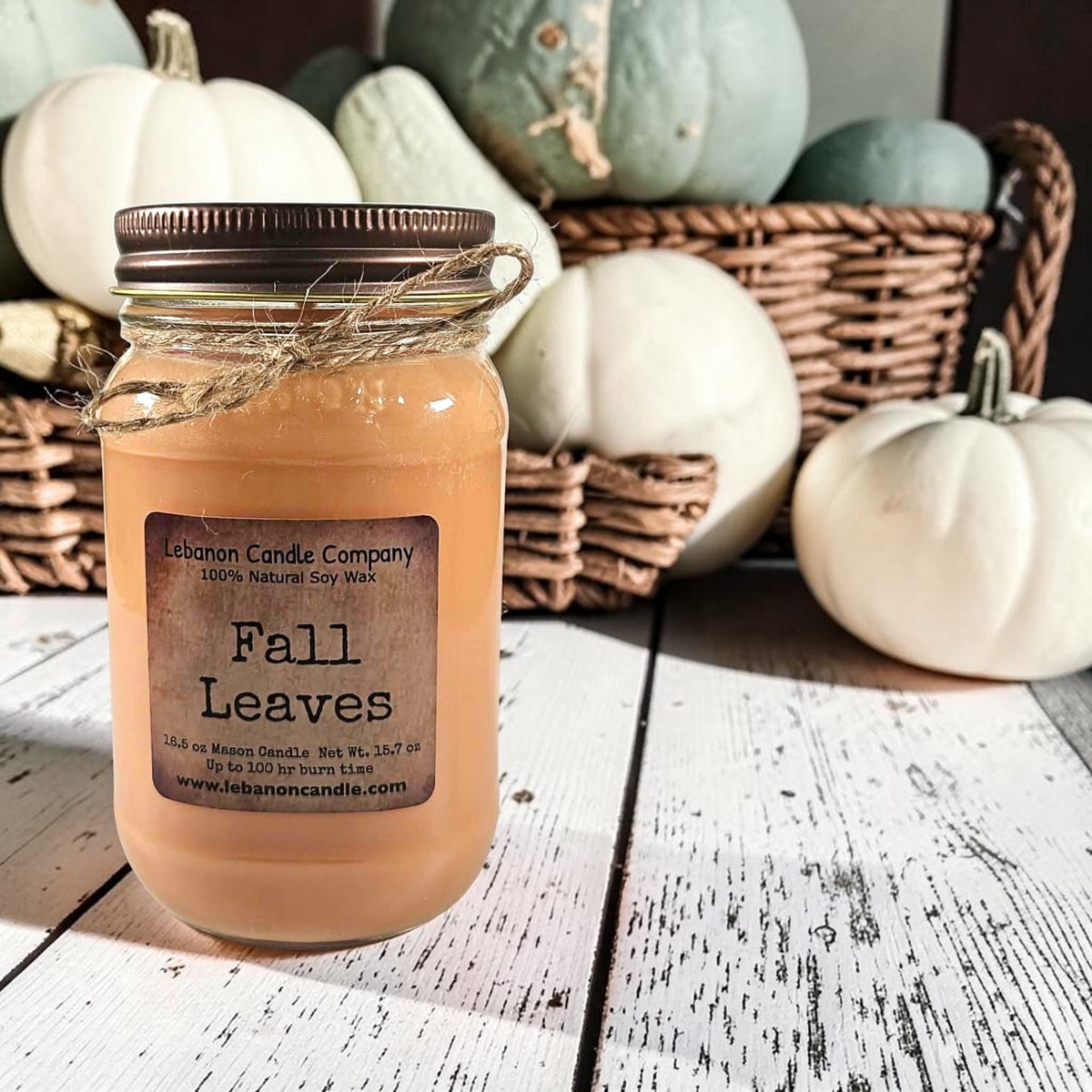 Amber jar candle with dark lid, twine ties, and “Fall Leaves” label on front