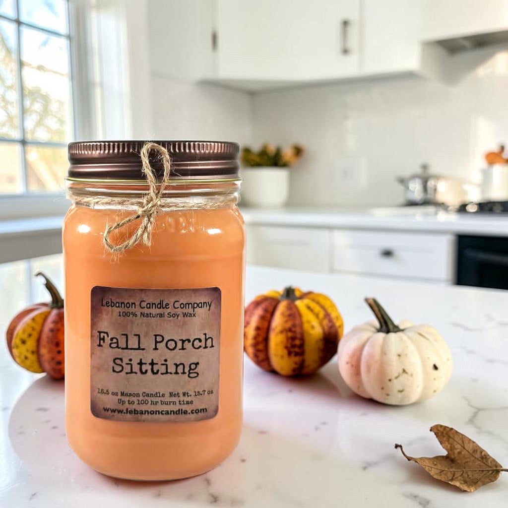 Fall Porch Sitting soy wax candle in amber jar with pumpkins on countertop
