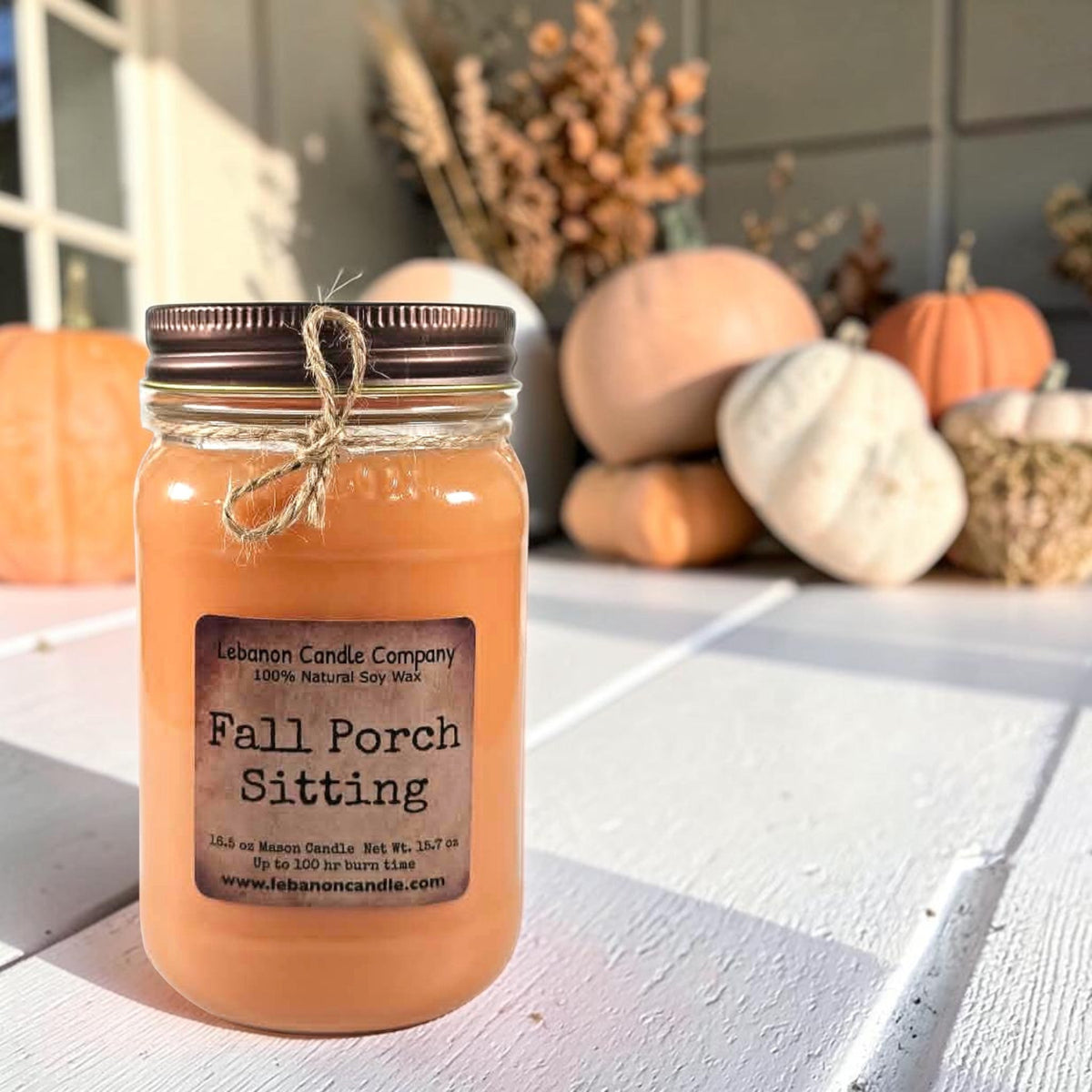 Fall Porch Sitting soy wax candle in amber glass jar on white porch table