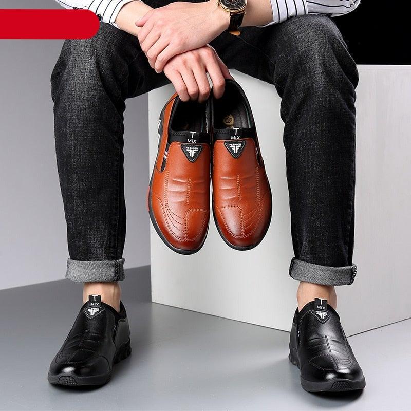 Pair of orange leather slip-on sneakers shown being held, with textured non-slip outsole