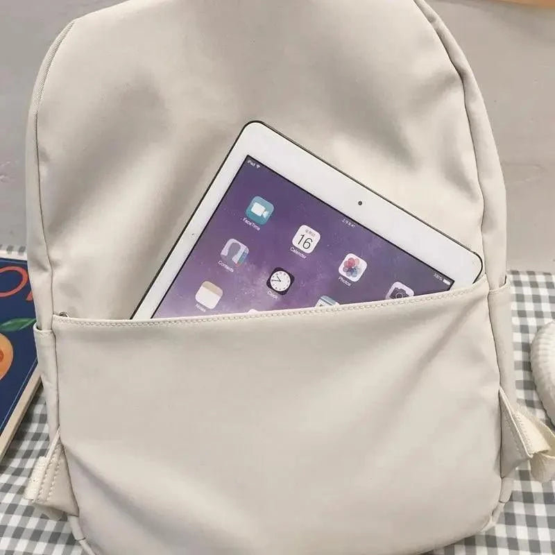 Beige backpack with open top showing tablet inside, front close-up