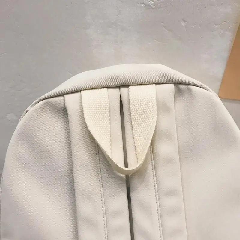 Off-white backpack with textured drawstring hood and adjustable shoulder straps