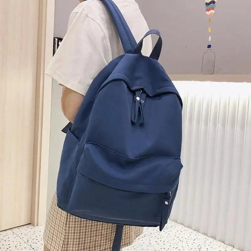 Navy canvas backpack with front pocket and adjustable shoulder straps