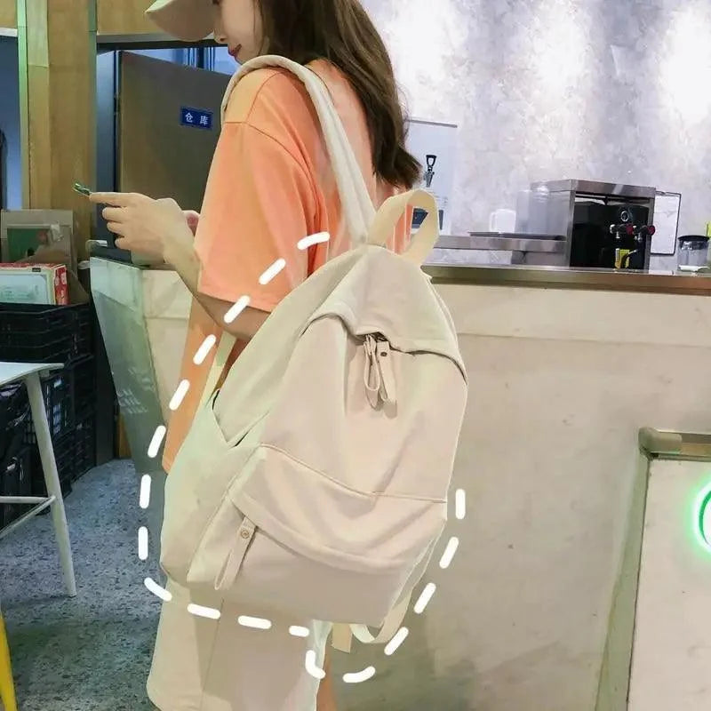 Cream backpack with drawstring top, front pocket, and adjustable shoulder straps