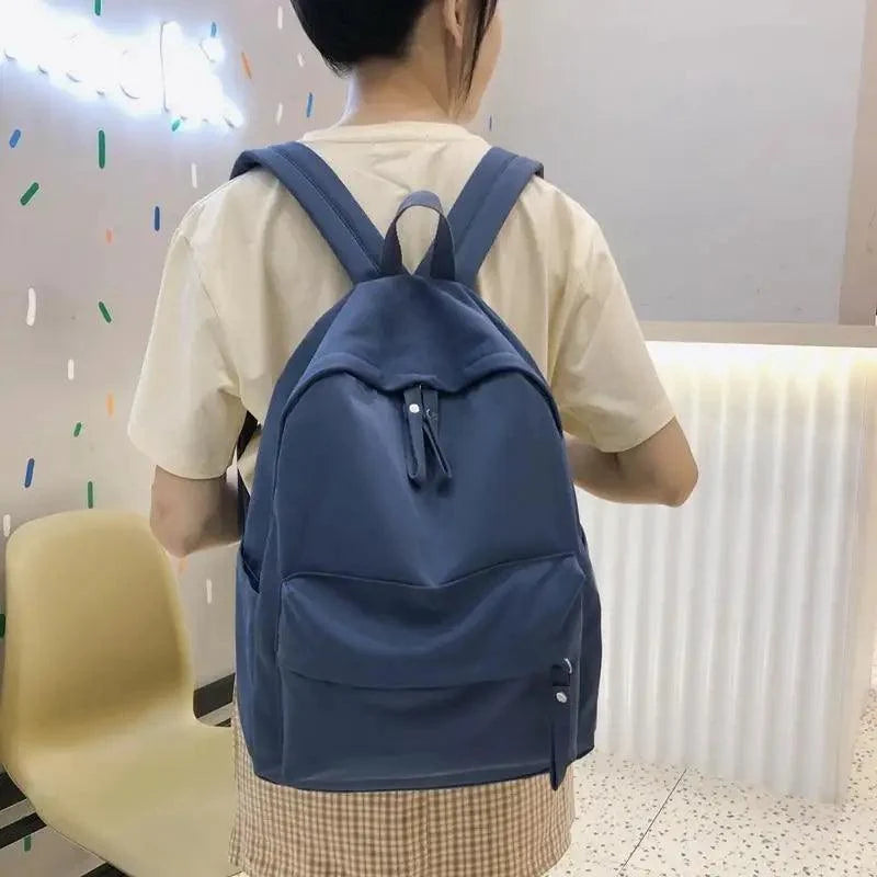 Navy backpack with top loop, front pocket, and adjustable shoulder straps