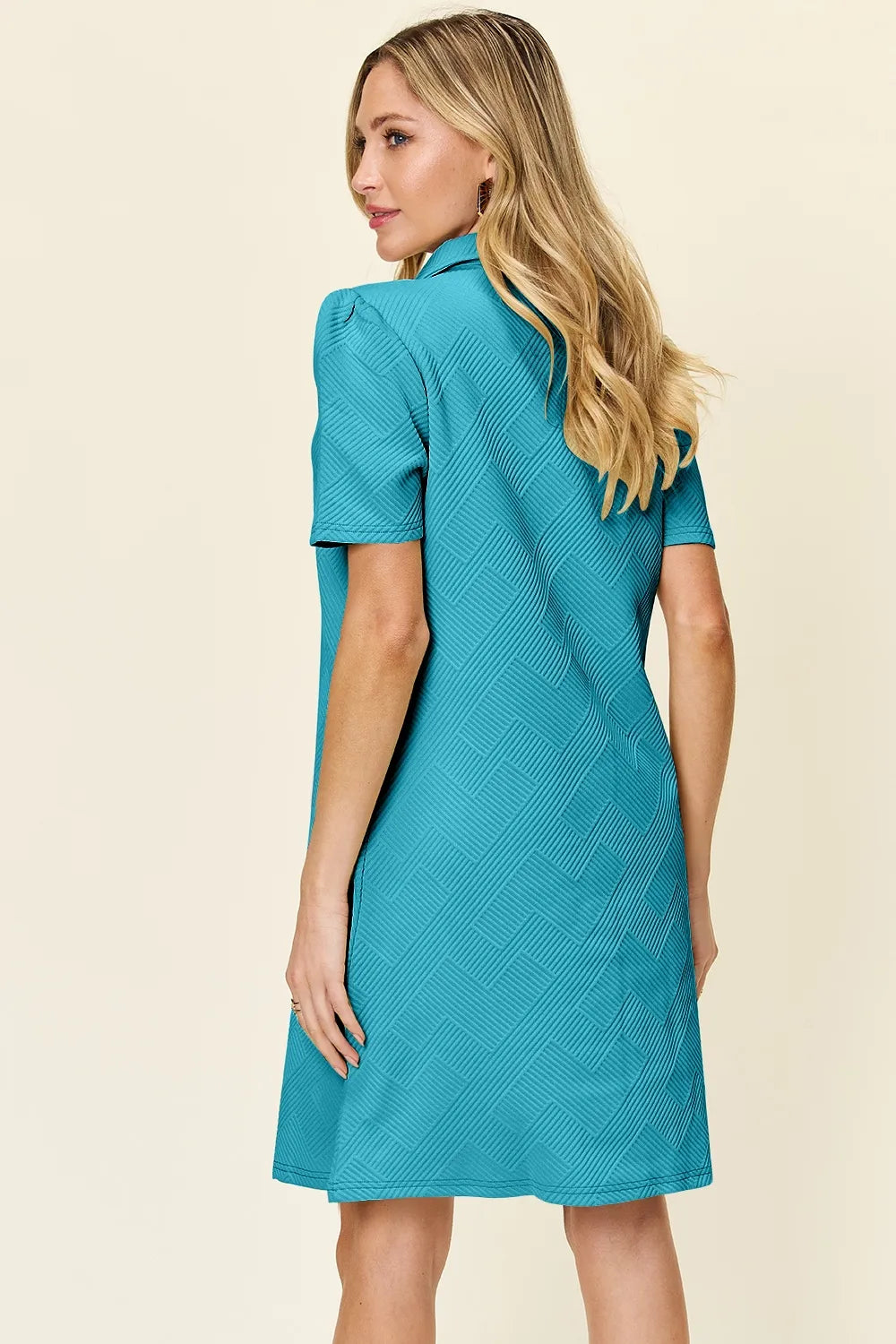 Teal textured collared short-sleeve dress with V neckline, angled side profile.