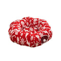 Red donut-shaped cat bed with white snowflake pattern and circular tunnel entrance