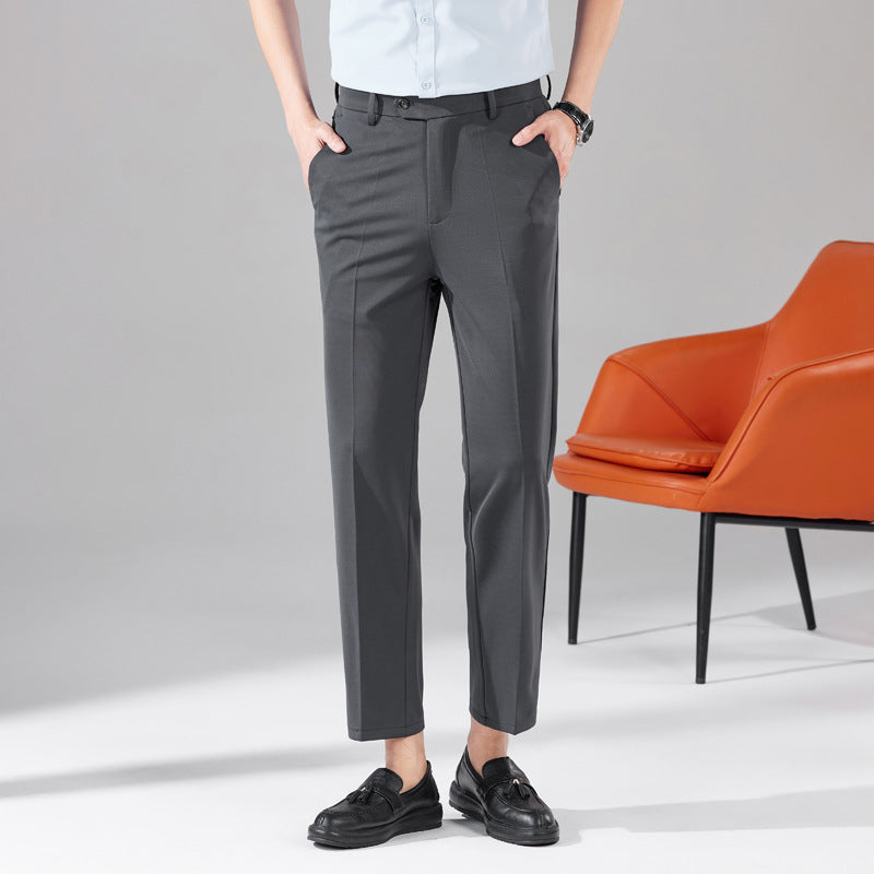 Dark gray dress trousers with belt loops, front crease, and tapered ankle hem