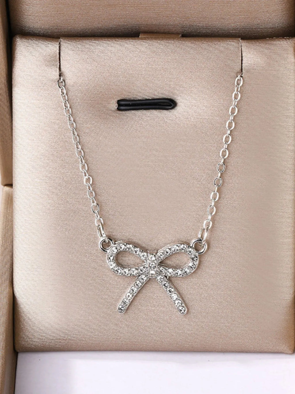 Silver bow-knot pendant necklace with clear stones and link chain on gift box