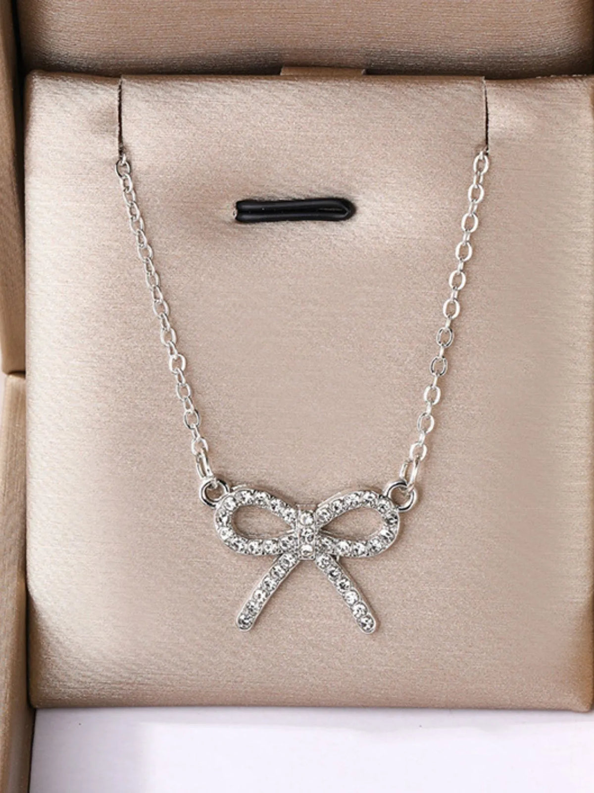 Silver bow-knot pendant necklace with clear stones and link chain on gift box