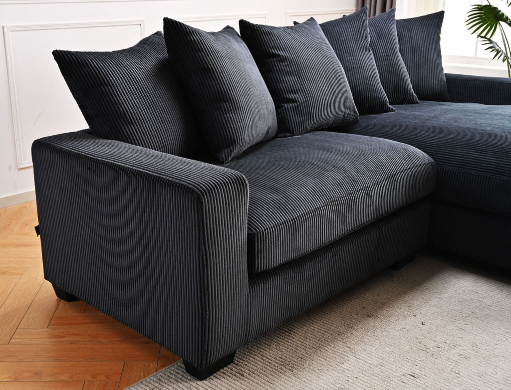 Dark gray/black L-shaped sectional sofa with chaise and tall back pillows