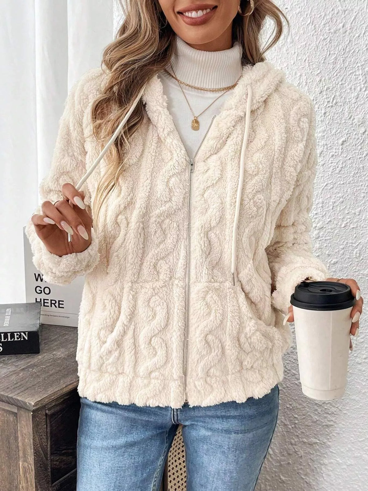 Ivory textured fleece zip-up hoodie with hood and drawstring, holding a white cup