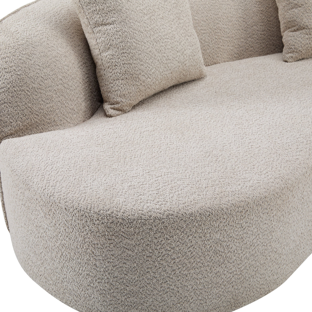 Light beige sofa seat cushion close-up with stitched seam and throw pillow