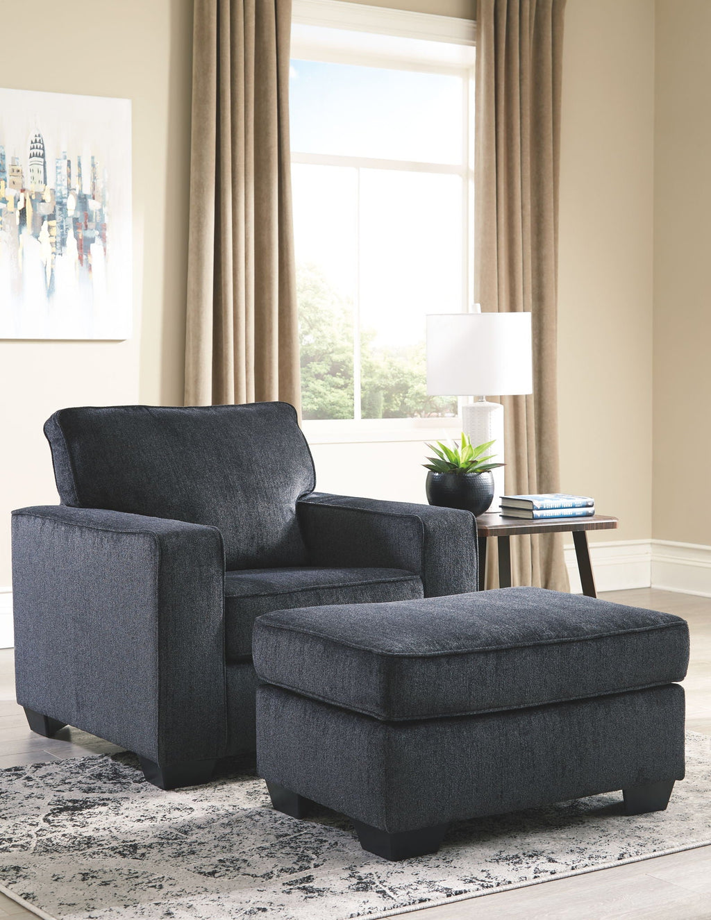 Dark gray upholstered armchair with matching ottoman and fabric cushion tops
