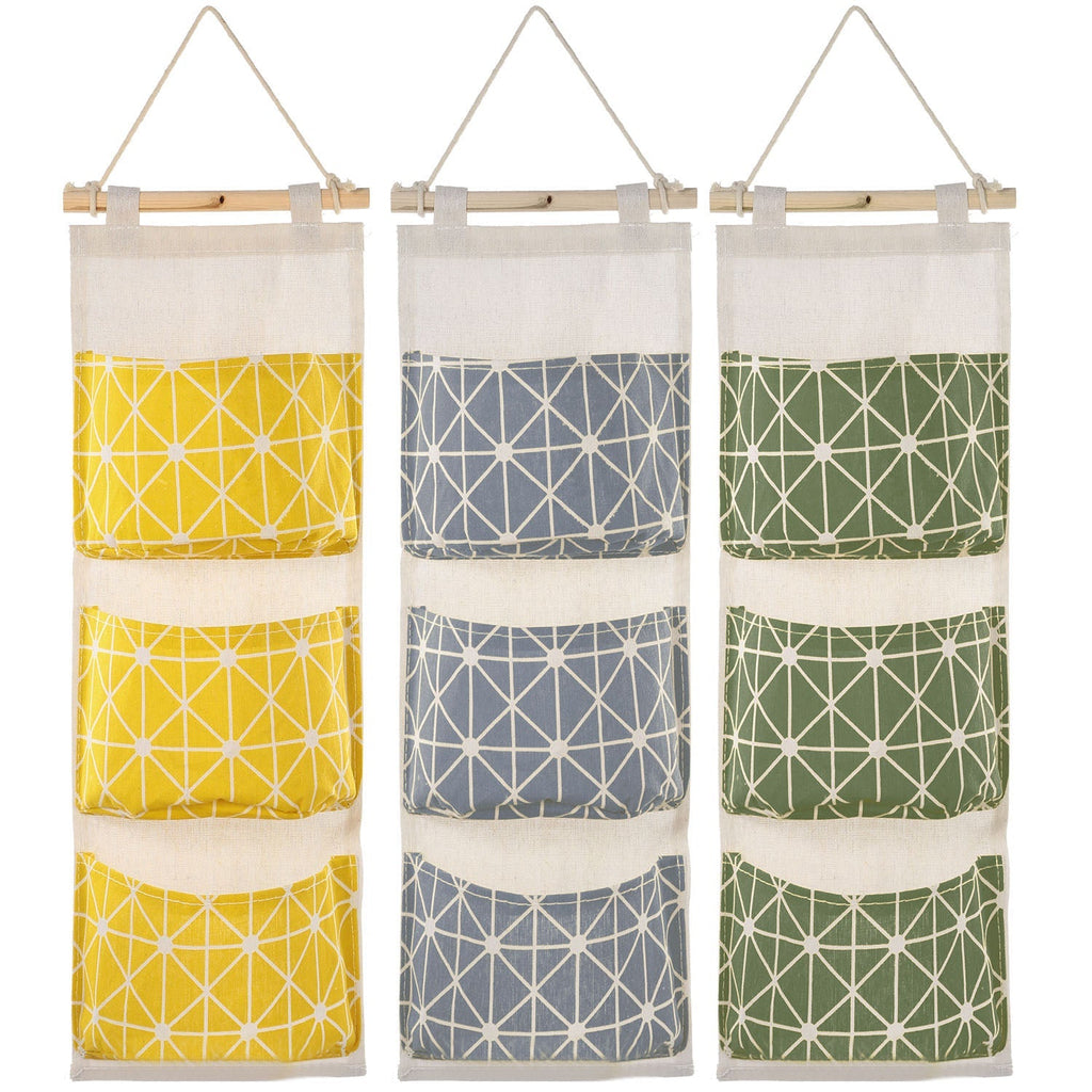 Three hanging storage pouches with geometric prints in yellow, gray, and green