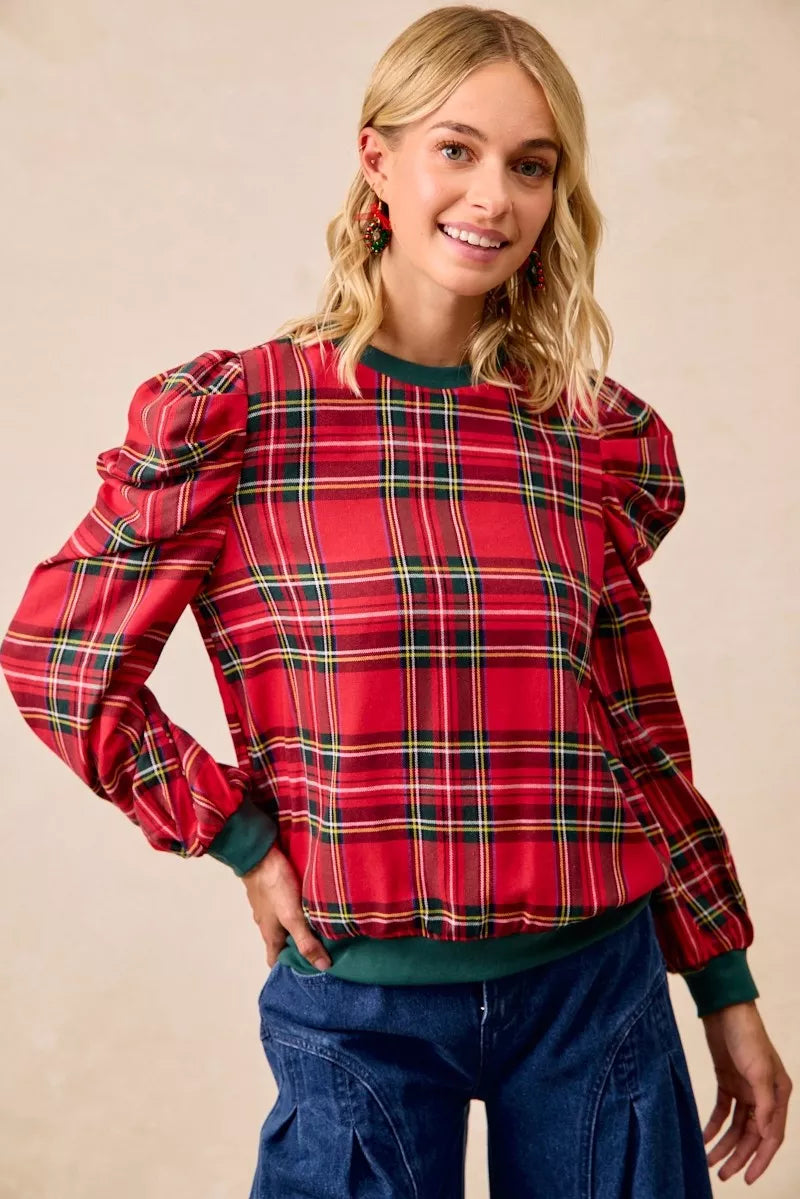 Red plaid puff-sleeve top with exaggerated shoulders and green neckline trim