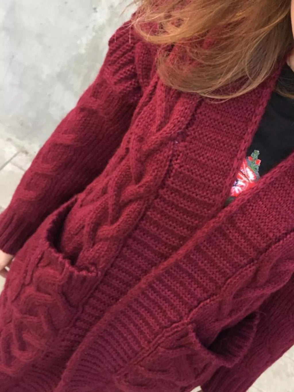 Burgundy chunky knit cardigan sleeve detail with braided cable pattern
