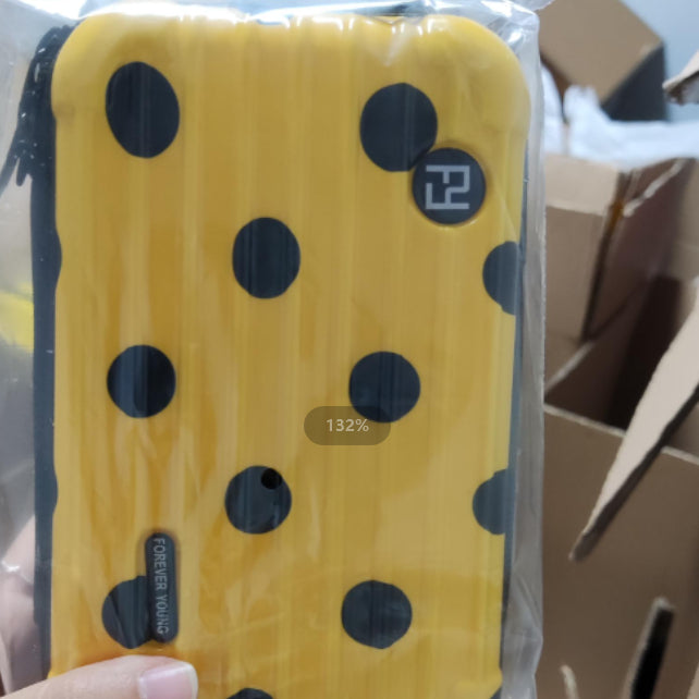 Cosmetic bag in yellow with black polka dots and small badge label.