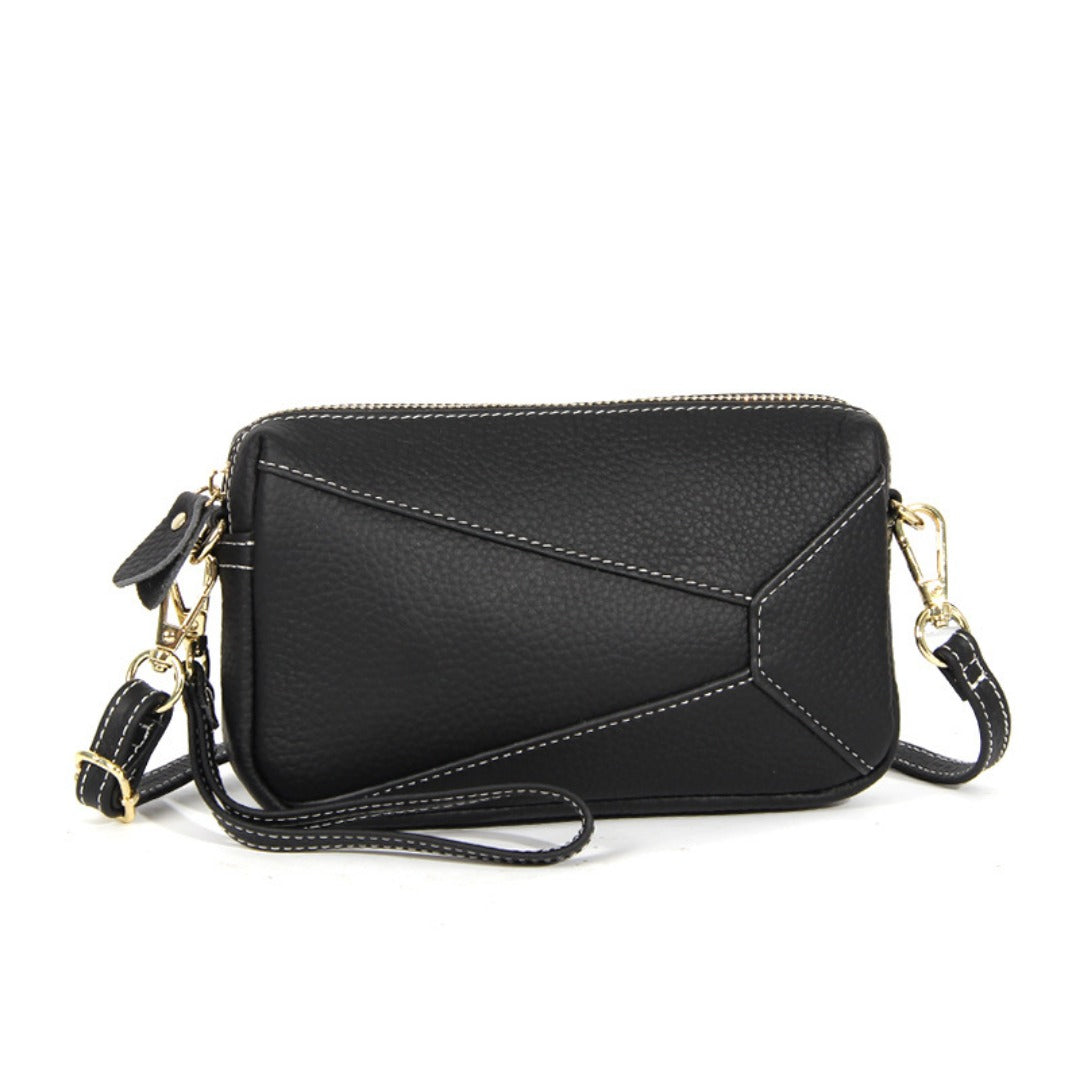 Black leather wristlet crossbody bag with gold-tone chain strap and zip top