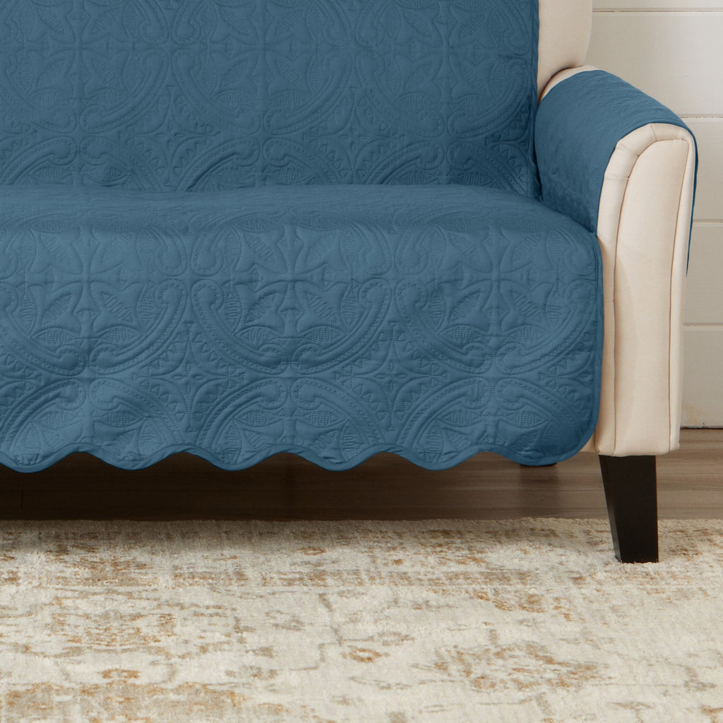 Blue medallion sofa protector with beige side piping and quilted skirt hem