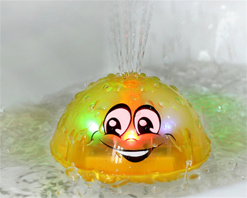 Yellow UFO water sprinkler toy with smiling face, clear water spray over dome