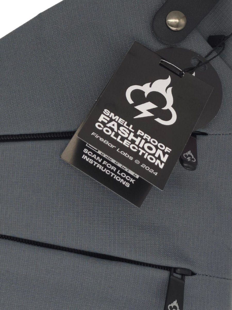 Gray crossbody bag front with “smell proof” lock label and zipper detail.