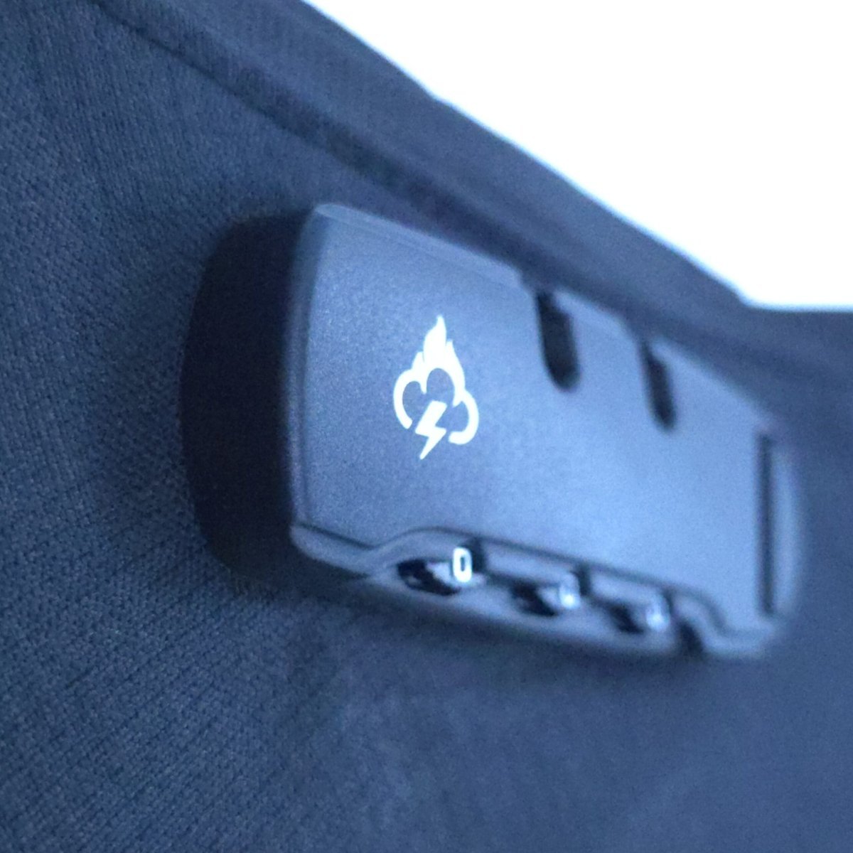 Smell-proof crossbody bag with small emblem and zipper area on dark fabric