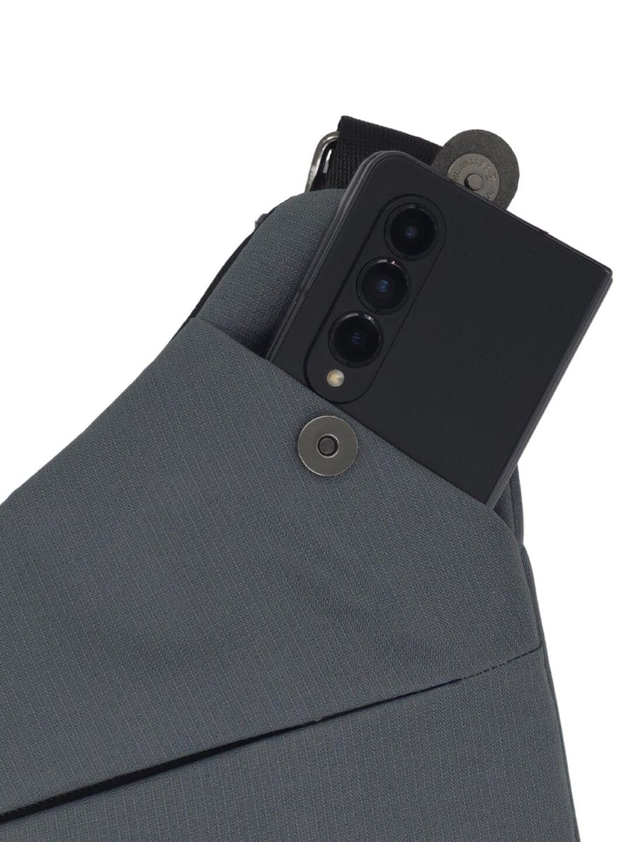 Gray crossbody bag showing interior with multiple smartphone slots and metal snap flap.