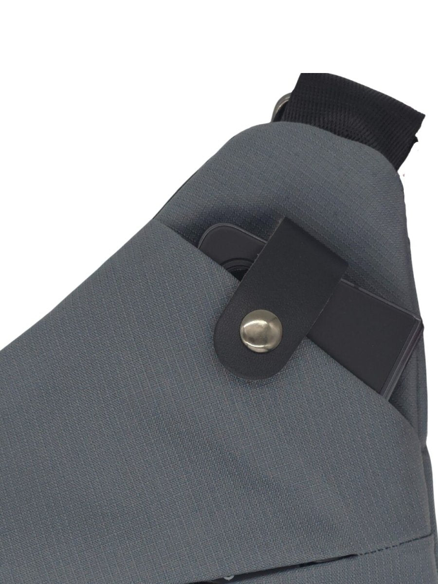 Gray crossbody bag with black adjustable strap and round metal snap closure on flap.