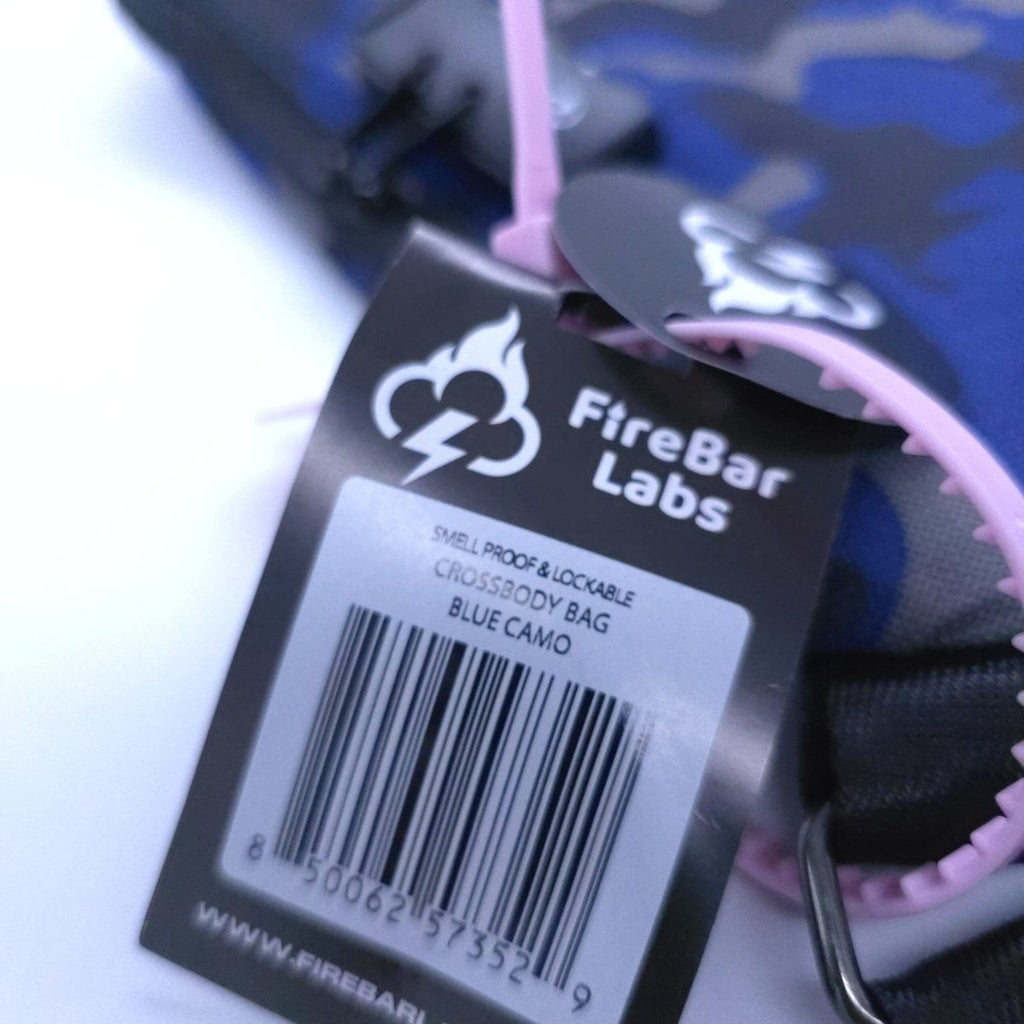 Smell-proof crossbody bag with FireBar Labs hang tag on camo fabric