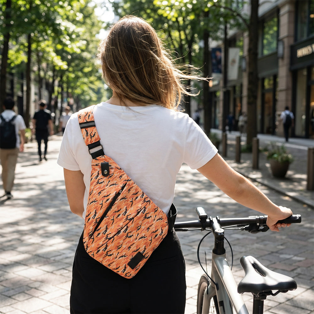 Orange camouflage crossbody bag worn crossbody with black strap over white shirt