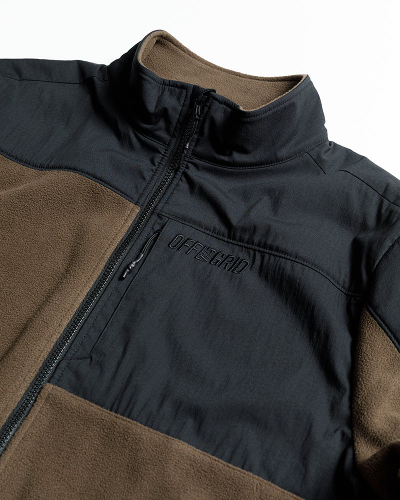 Upper chest close-up of two-tone fleece zip-up jacket with stand collar and zipper.