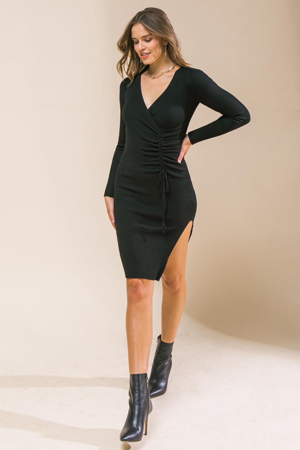 Black sweater dress with V-neck, long sleeves, ruched waist, and high side slit