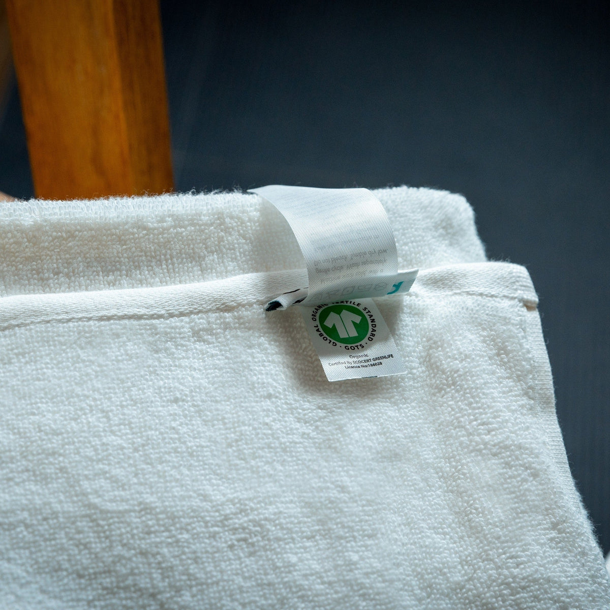 Close-up of white bath mat with certification tag on top