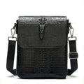 Front view black croc-embossed leather sling bag with snap flap and shoulder strap