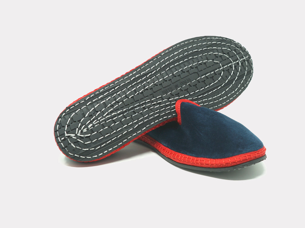 Navy slip-on slippers underside view with stitched patterned outsole and red edge trim