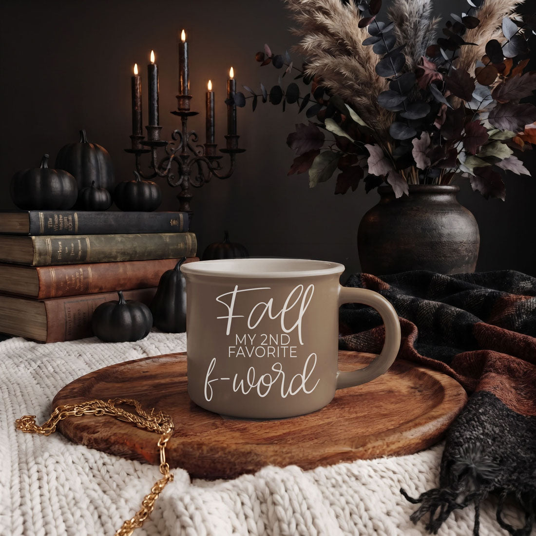 Beige ceramic mug with white quote on a wooden tray atop a white knit blanket